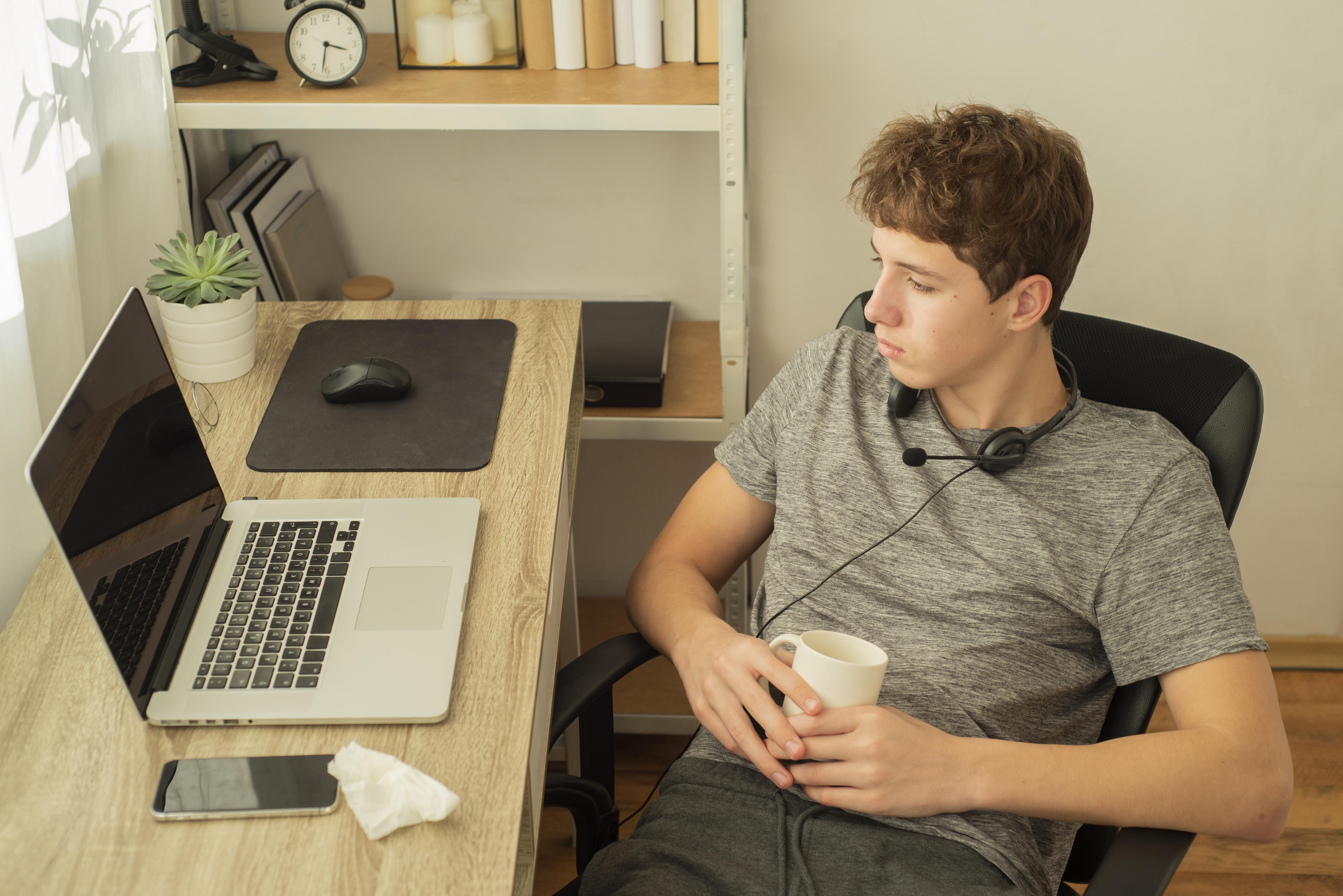 Young man working from home office with headset and laptop
