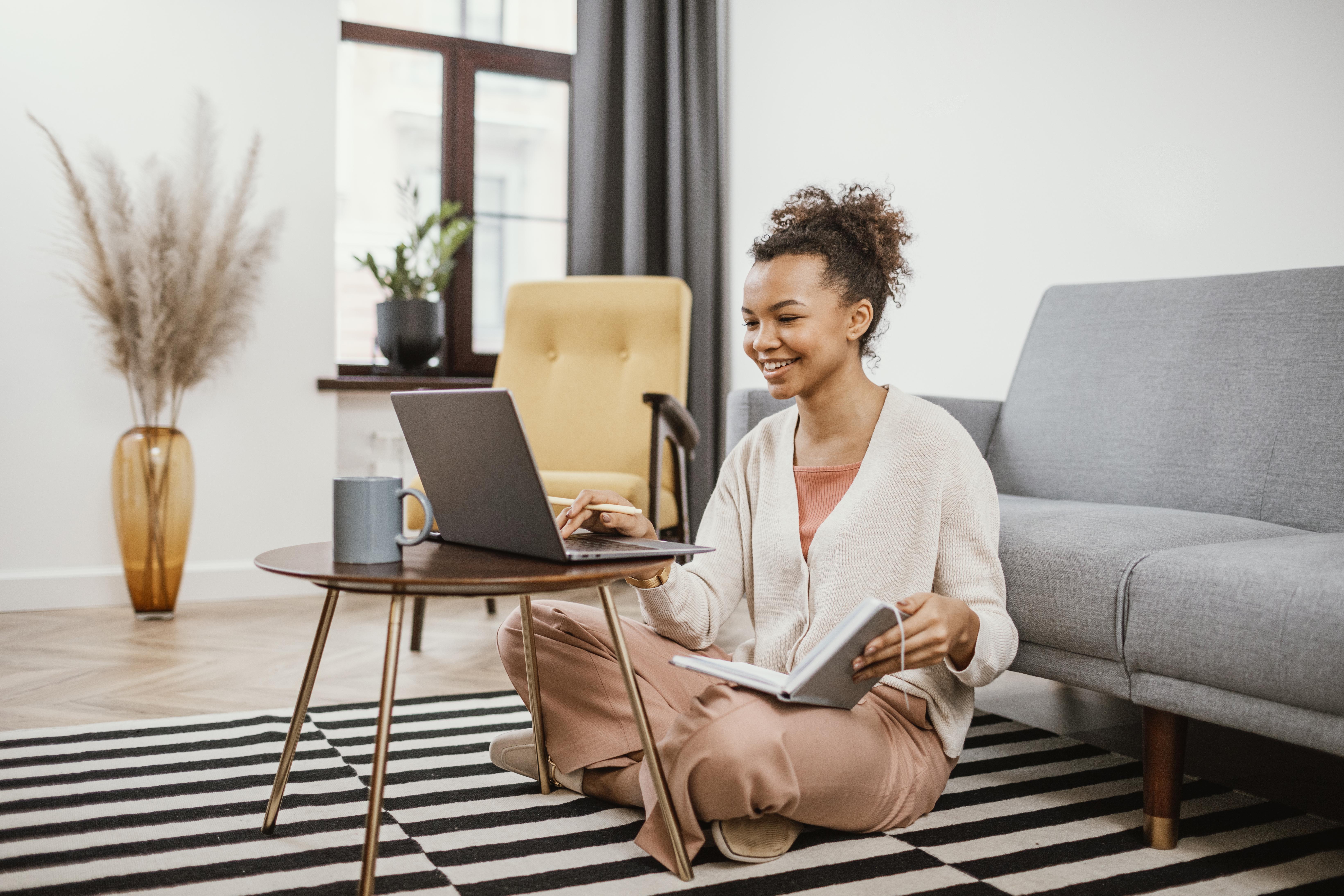 Young woman working from home on laptop in comfortable living room setting